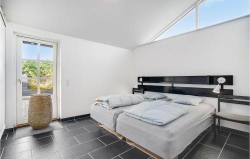 Pollerup KullegårdにあるCozy Home In Stege With Wifiの白い部屋で、ベッド2台、窓が備わります。