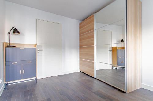 een grote glazen wand in een kamer met houten vloeren bij Appartement neuf, lumineux & cosy proche La Défense, Neuilly & Paris in Puteaux