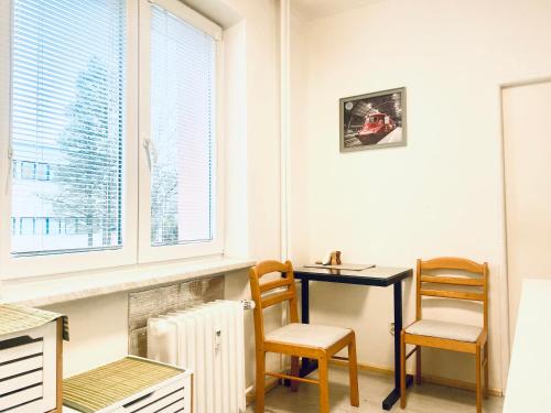 a room with a desk and two chairs and a window at Apartmán Tatra Kopřivnice in Kopřivnice