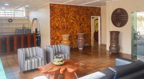 a living room with two chairs and a table at Pers Palace Hotel in Santa Inês