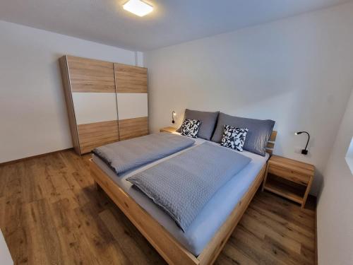 Schlafzimmer mit einem großen Bett mit einem Kopfteil aus Holz in der Unterkunft Apart Madeleine in Sankt Leonhard im Pitztal