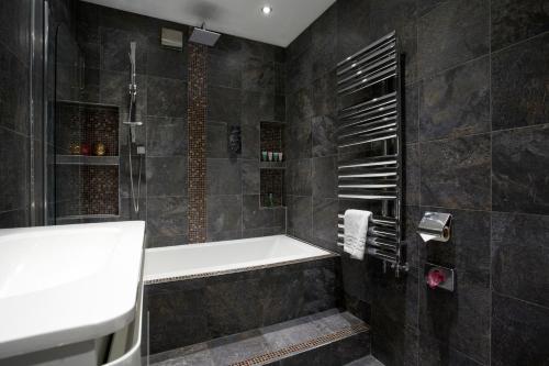 a bathroom with a shower and a bath tub at Harrogate Self Catering - Mews Suite - Garden in Harrogate