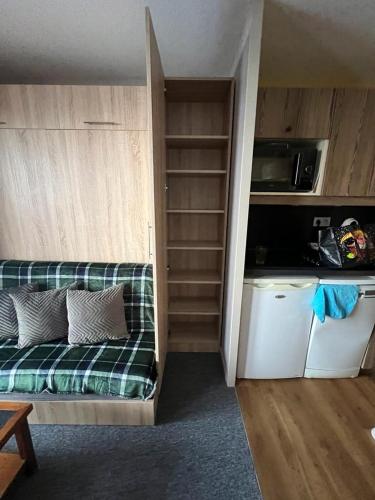 une petite chambre avec un canapé et une cuisine dans l'établissement Studio 942-Particulier-Résidence L'Ours Blanc-Alpe d'Huez-Centre Station, à L'Alpe-d'Huez