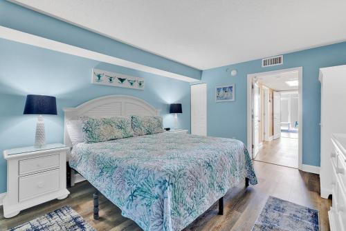 1 dormitorio con cama y pared azul en Bay Watch Resort 1203 - Perfect Oceanside Getaway en Myrtle Beach