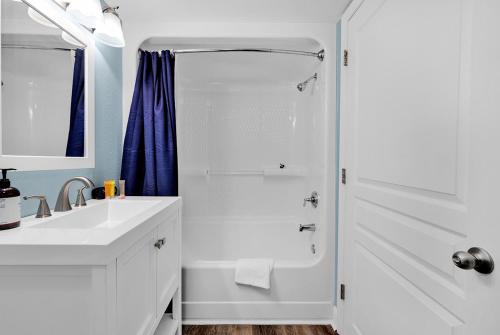 a white bathroom with a shower and a sink at Bay Watch Resort 1203 - Perfect Oceanside Getaway in Myrtle Beach