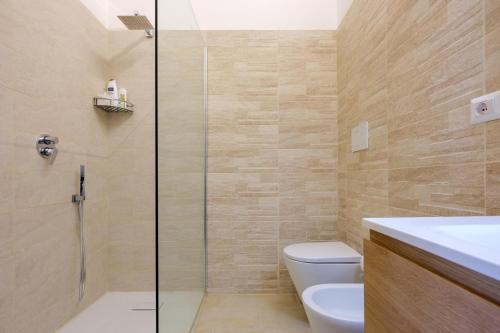 a bathroom with a shower and a toilet and a sink at Villa Reale Flats in Lecce