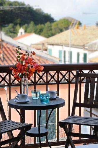 a table with a vase of flowers on a balcony at Anelina Paxos Residences ( Nafsika Apartment) in Gaios