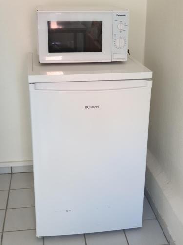 eine Mikrowelle auf einem weißen Kühlschrank in der Unterkunft gemütliche Gäste Suite im Herzen von Neumünster in Neumünster