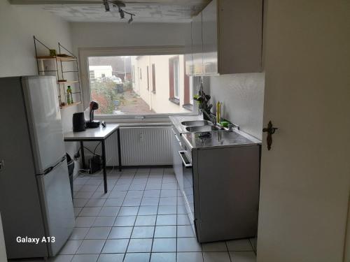 eine kleine Küche mit Spüle und Kühlschrank in der Unterkunft gemütliche Gäste Suite im Herzen von Neumünster in Neumünster