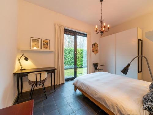 een slaapkamer met een bed, een bureau en een raam bij Cozy forest villa on the water near Harderwijk in Zeewolde