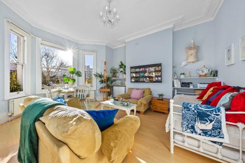 a living room with a bed and a couch at Artist's Bright Hampstead Heath Village 2 bed in London