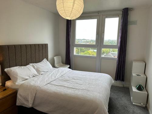 een slaapkamer met een bed en een groot raam bij Private room in Glasgow City Center in Glasgow