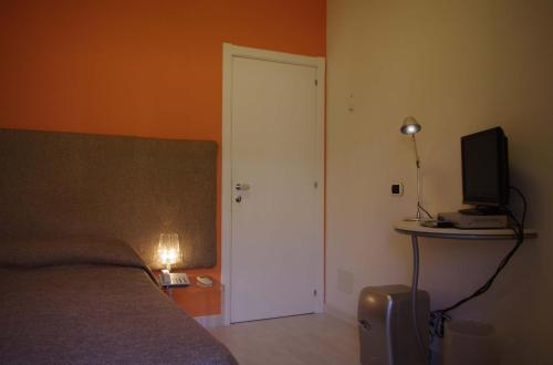 a bedroom with a bed and a door with a television at La Piccola Locanda in Modica