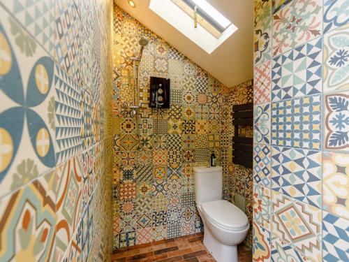 a bathroom with a toilet and a mosaic wall at 1 bed property in Hexham 82782 