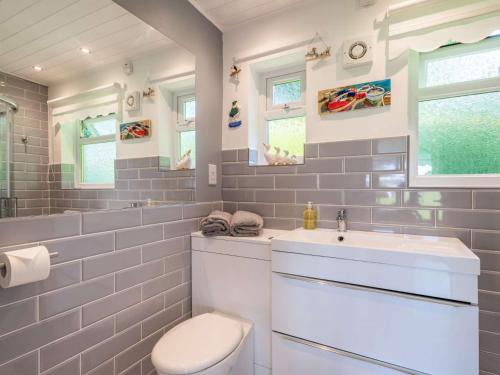 a bathroom with a white toilet and a sink at 2 Bed in Mundesley 83661 in Mundesley