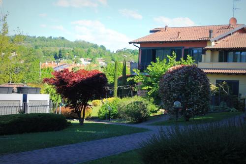 a garden with a house and trees and bushes at Hotel Residence Montelago in Ternate