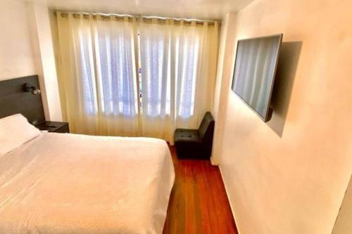 a hotel room with a bed and a television at Apartamento Andahuaylas in Andahuaylas