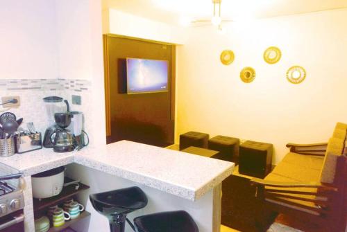 a kitchen with a counter and stools in a room at Apartamento Andahuaylas in Andahuaylas