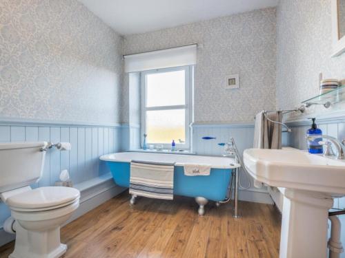 a bathroom with a tub and a toilet and a sink at 2 Bed in Ravenglass SZ514 in Ravenglass
