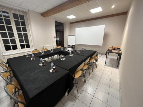 a conference room with tables and chairs and a whiteboard at Hôtellerie Saint Yves in Chartres