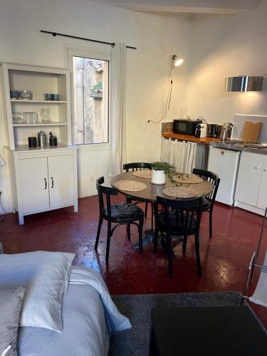 a room with a table and chairs and a kitchen at Studio en ville in Apt