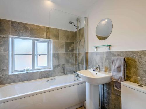 y baño con lavamanos, bañera y lavamanos. en 2 Bed in Mundesley 83314 en Mundesley