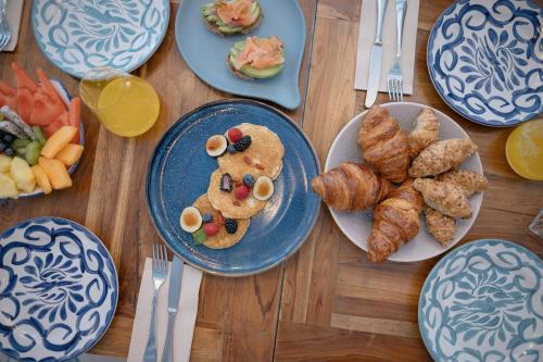 a table with plates of food with croissants and pastries at MYR Plaza Mercado & Spa in Valencia