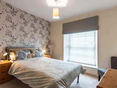 a bedroom with a large bed and a window at 2 Bed in Tenby 83211 in Tenby