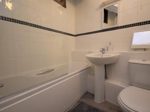 a white bathroom with a sink and a toilet at 2 Bed in Tenby 83211 in Tenby