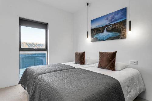 a bedroom with two beds and a large window at Luxury Villa in the South - Perfect Location in Ölfus