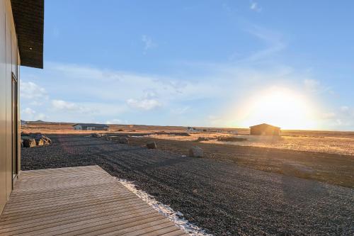 a wooden walkway in a field with the sun setting at Luxury Villa in the South - Perfect Location in Ölfus
