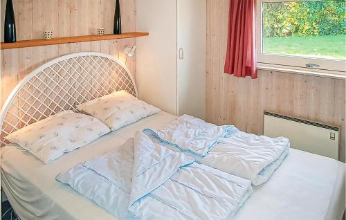 a bed in a room with two pillows on it at Nice Home In Sjlund With 3 Bedrooms, Sauna And Wifi in Hejls