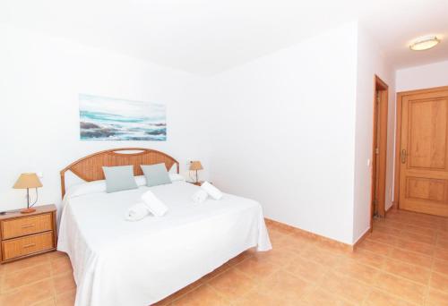 a bedroom with a white bed in a room at Villa Mirador B by Sonne Villas in Cala Galdana
