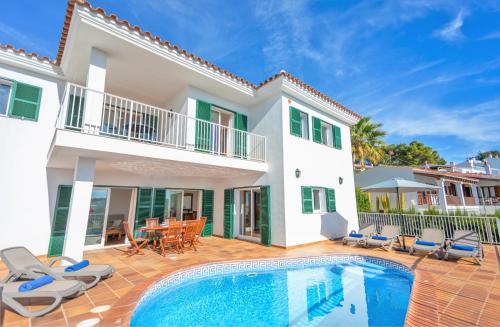 a villa with a swimming pool in front of a house at Villa Mirador B by Sonne Villas in Cala Galdana