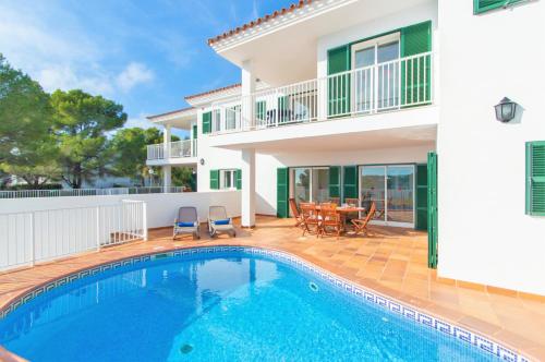 a villa with a swimming pool in front of a house at Villa Mirador B by Sonne Villas in Cala Galdana