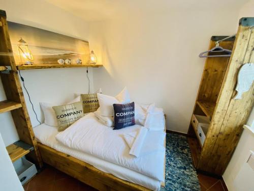 un lit avec des oreillers dessus dans une chambre dans l'établissement Ferienhaus Strandkoje, à Warnemünde