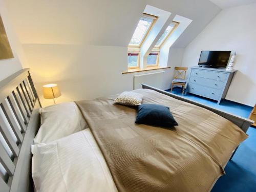 um quarto com uma cama grande e uma televisão em Ferienhaus Waterkant em Warnemünde