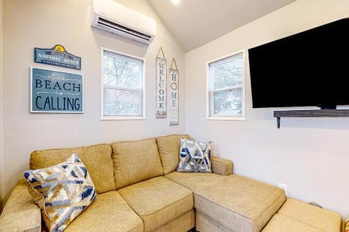 a living room with a couch and a flat screen tv at The Tiny Haven in Navarre
