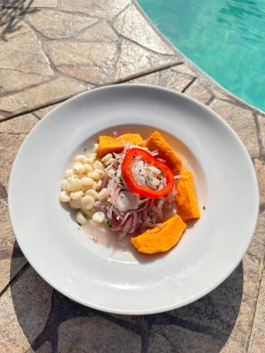 a plate of food on a table next to a pool at Hotel Puerto Antiguo in Los Órganos