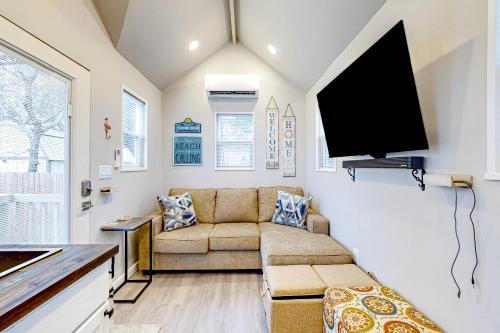 a living room with a couch and a flat screen tv at The Tiny Haven in Navarre