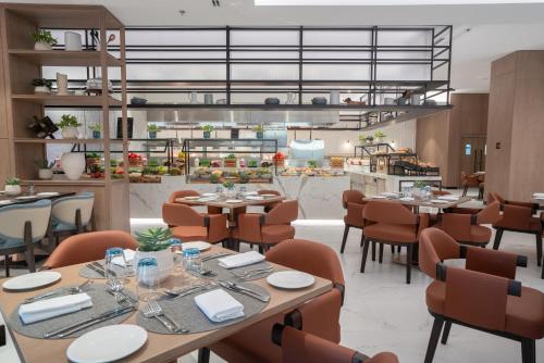 a restaurant with tables and chairs and a kitchen at Amwaj Rotana, Jumeirah Beach - Dubai in Dubai