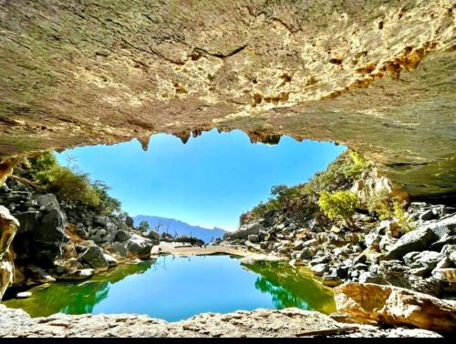 a view of a river from inside a cave at Sunset view hill jabal shams in Misfāh
