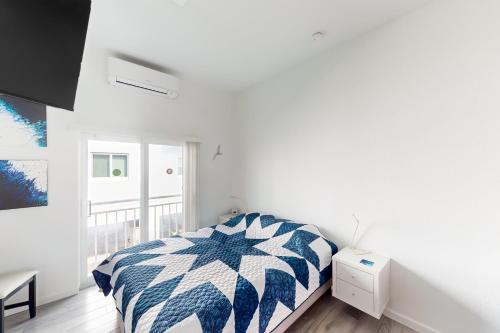 um quarto com uma cama com um edredão azul e branco em Ocean Isles 50 em Marathon