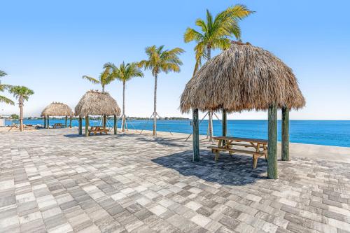 a bench on a beach with palm trees and the ocean at Ocean Isles 50 in Marathon