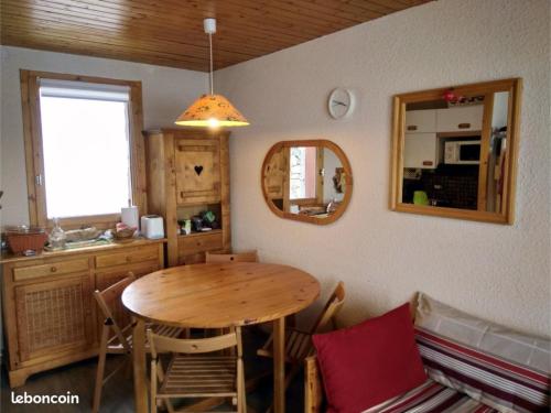 a dining room with a table and a kitchen at Appartement Les Sonnailles in Les Allues