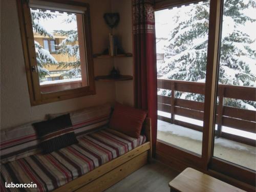 a room with a bench in front of two windows at Appartement Les Sonnailles in Les Allues