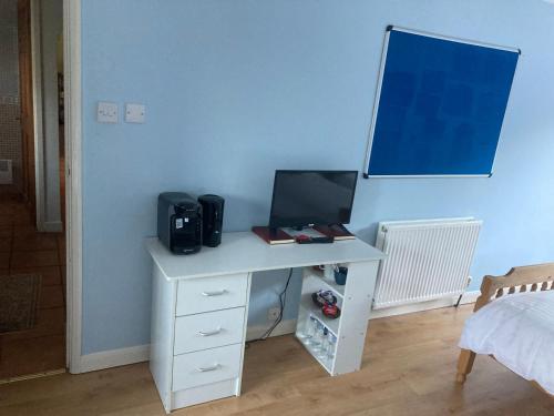 a desk with a computer on it in a bedroom at Bluebelle in Bray