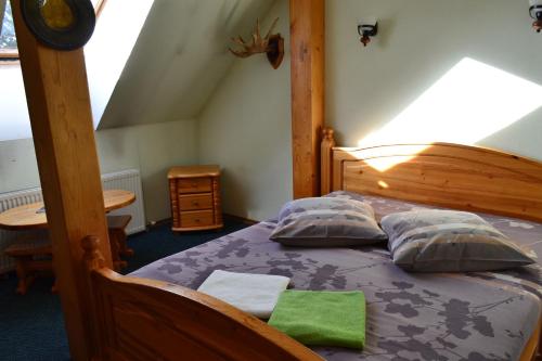 een slaapkamer met een houten bed met 2 kussens bij Motelis Aka in Kārsava