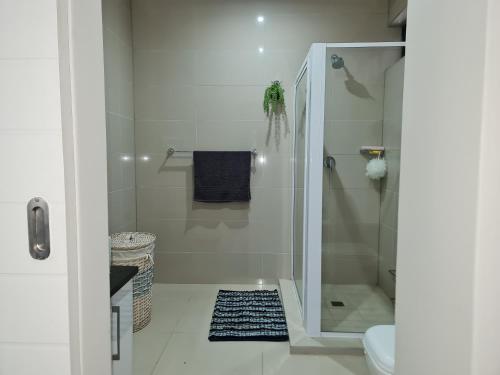 a bathroom with a shower and a black rug at 17 Santana Pebbles Penthouse in La Mercy