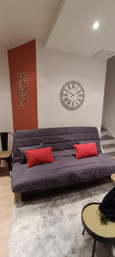a large couch in a room with a clock on the wall at Résidence Bel'Air in Aire-sur-la-Lys